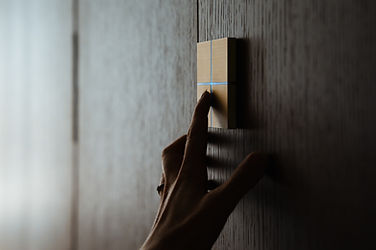 Hand bedient ein modernes Touchpanel an dunkler Holzwand, Produktfotografie für Brands in der Zentralschweiz