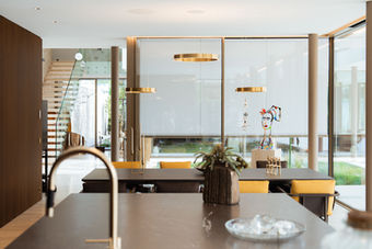 Moderne Küche mit Holzfronten, Hängeleuchten und Treppe, Interieurfotografie für Unternehmen in der Zentralschweiz