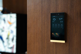 Smartes Bedienpanel mit goldenem Rand an Holzwand, Produktfotografie für Start-ups und Brands