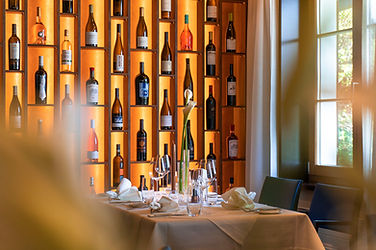 Restaurant-Interieur mit beleuchtetem Weinregal und gedecktem Tisch, Gastronomiefotografie in Luzern