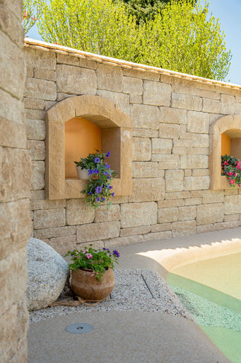 Aussenbereich mit Natursteinmauer, Blumen und Pool, Architekturfotografie in der Zentralschweiz