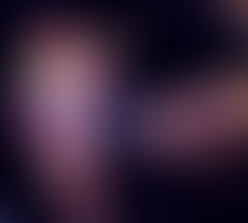 Amethistè Allustria Amor mid dance routine in shorts and a vest top with a pride flag wrapped around her shoulders and her eyes closed.Photo by Courtney Gunn.