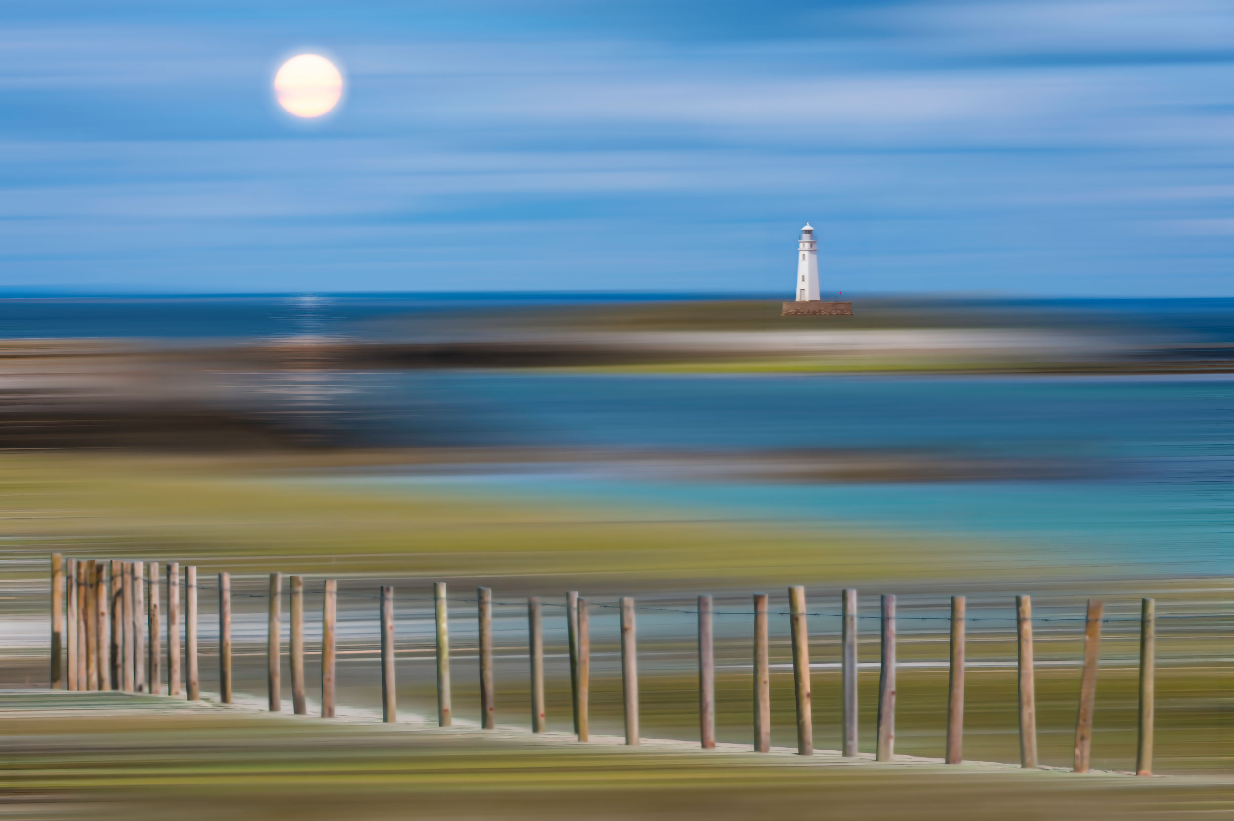 Tirage photographique décoratif des Glénan, paysage de phare sous une lune douce, mer émeraude et effet artistique vaporeux.
