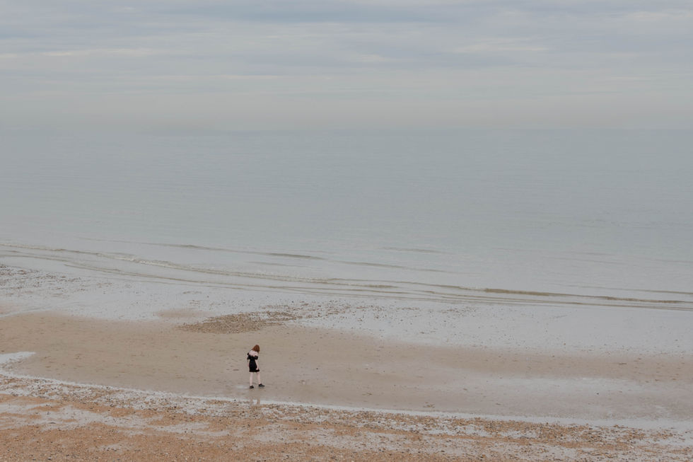 Women walking towards sea as seen from above on British coast