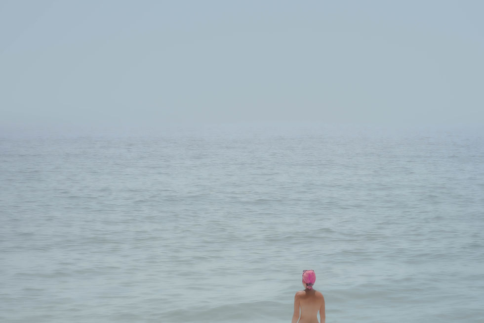 Woman with pink hair in sea on coast of Crete.