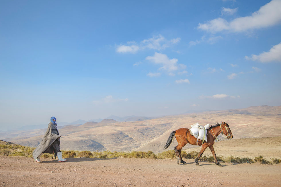 horseman walking behind his horse in Lesotho mountains