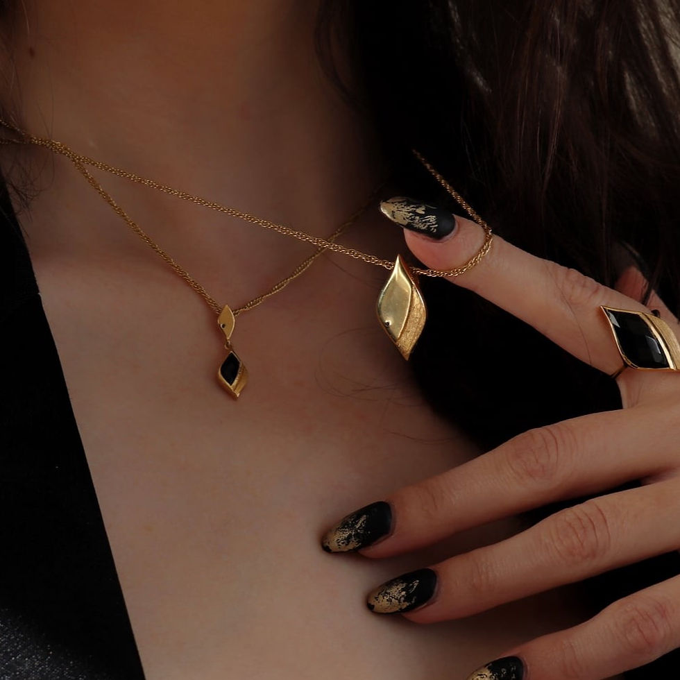 Thumbnail: Gold asymmetric shape pendant necklace set with tiny black stone, worn by model