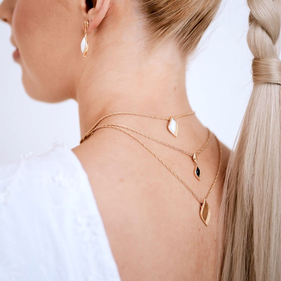 Thumbnail: Gold asymmetric shape pendant necklace set with tiny black stone, worn by model