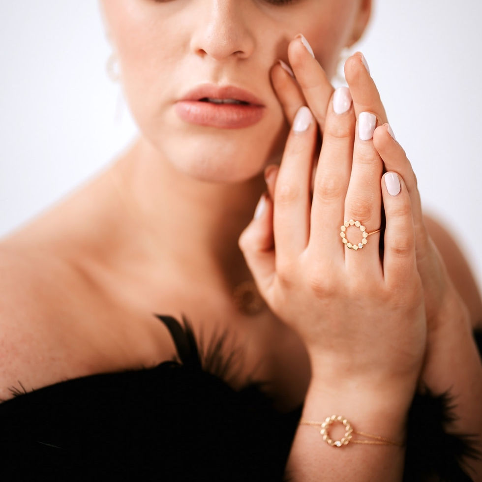 Thumbnail: Image of a model wearing gold bracelet featuring a circular pendant featuring clear cubic zirconia.