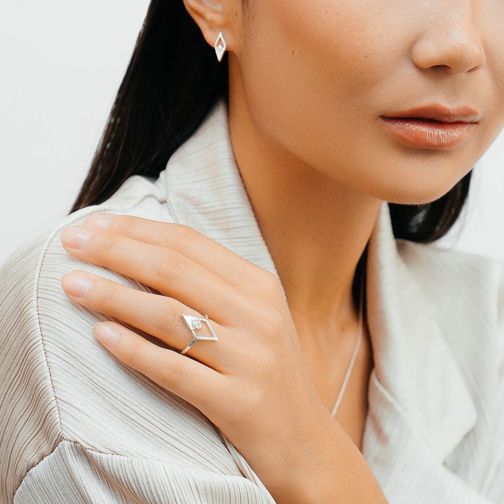 Thumbnail: Model wearing silver ring with diamond shape centre set with cubic zirconia