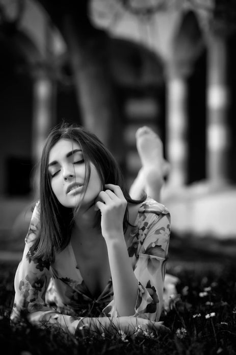Ritratto in bianco e nero di una donna distesa su un prato