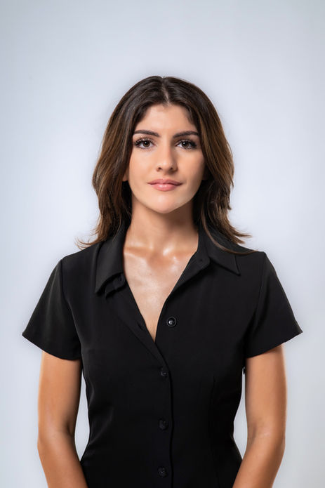 Primo piano di una giovane donna bruna in abito nero.