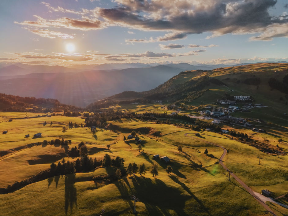Veduta aerea di colline verdi al tramonto.