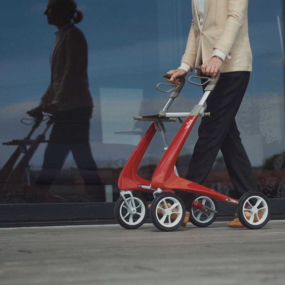 Thumbnail: Person pushing a red walker with wheels, walking near a glass wall.