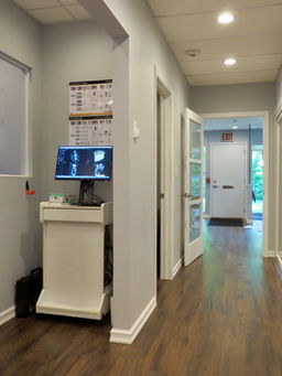 Hallway inside IES Endodontics showing a computer screen with x-rays ABOUT US. IES Endodontics