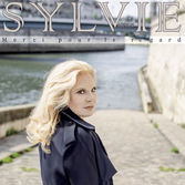 « On a rejoint l’estuaire/Et bravé les sanglots/Du ciel et ses colères/On a eu peur on a eu chaud. » La chanson « Le Bleu de la Mer Noire » ouvre le cinquantième album studio de Sylvie Vartan et donne le ton. Un album qui se compose de quatorze titres, très cohérents, aux textes puissants et à la nostalgie discrète, élégante et assumée.

Des thèmes personnels comme le retour à l’enfance, l’amour ou encore, l’abandon sont présents dans cet opus. D’après Sylvie, « “Le Bleu de la Mer Noire”, c’est une façon poétique d’aborder le thème de l’exil, l’image est très forte. C’est un peu mon histoire. ».


Léonard Lasry, Joseph d’Anvers et Clara Luciani font alors leur entrée en scène comme auteurs/compositeurs. Tous les trois travaillent pour la première fois avec Sylvie. Un album dont l’unité est remarquable avec des arrangements de grande qualité orchestrés par l’ami Philippe Russo. « Je crois que cet album est vraiment l’un de mes meilleurs, résume Sylvie. Tout est cohérent et chaque chanson me correspond ».


Une cohérence musicale que Sylvie célébrera également sur scène pour ses soixante ans de carrière en octobre 2021. Un spectacle sous le regard de son fidèle public à qui elle dira merci, forcément…