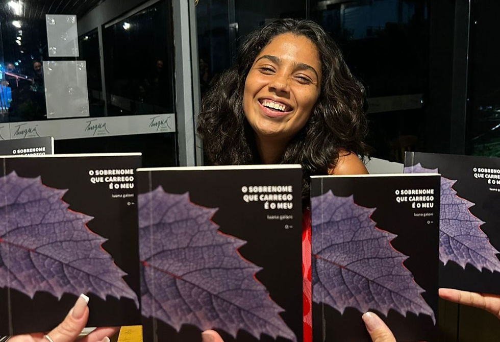 Luana Galoni sendo fotografada pelas psicólogas do projeto, junto ao seu livro, "O sobrenome que carrego é o meu".