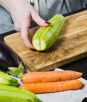 hands-chef-cut-zucchini-wooden-chopping-board_edited.png