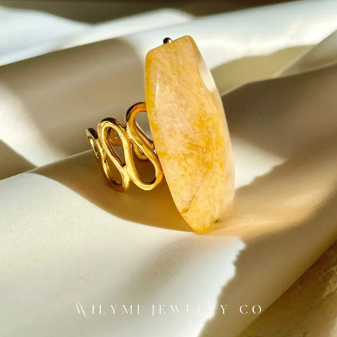 A collection of handcrafted statement rings by WILYMI Jewelry Co., featuring labradorite, rose quartz, yellow jade, turquoise, and floral designs. Ethically made in Toronto with sustainable materials, photographed in soft natural light.