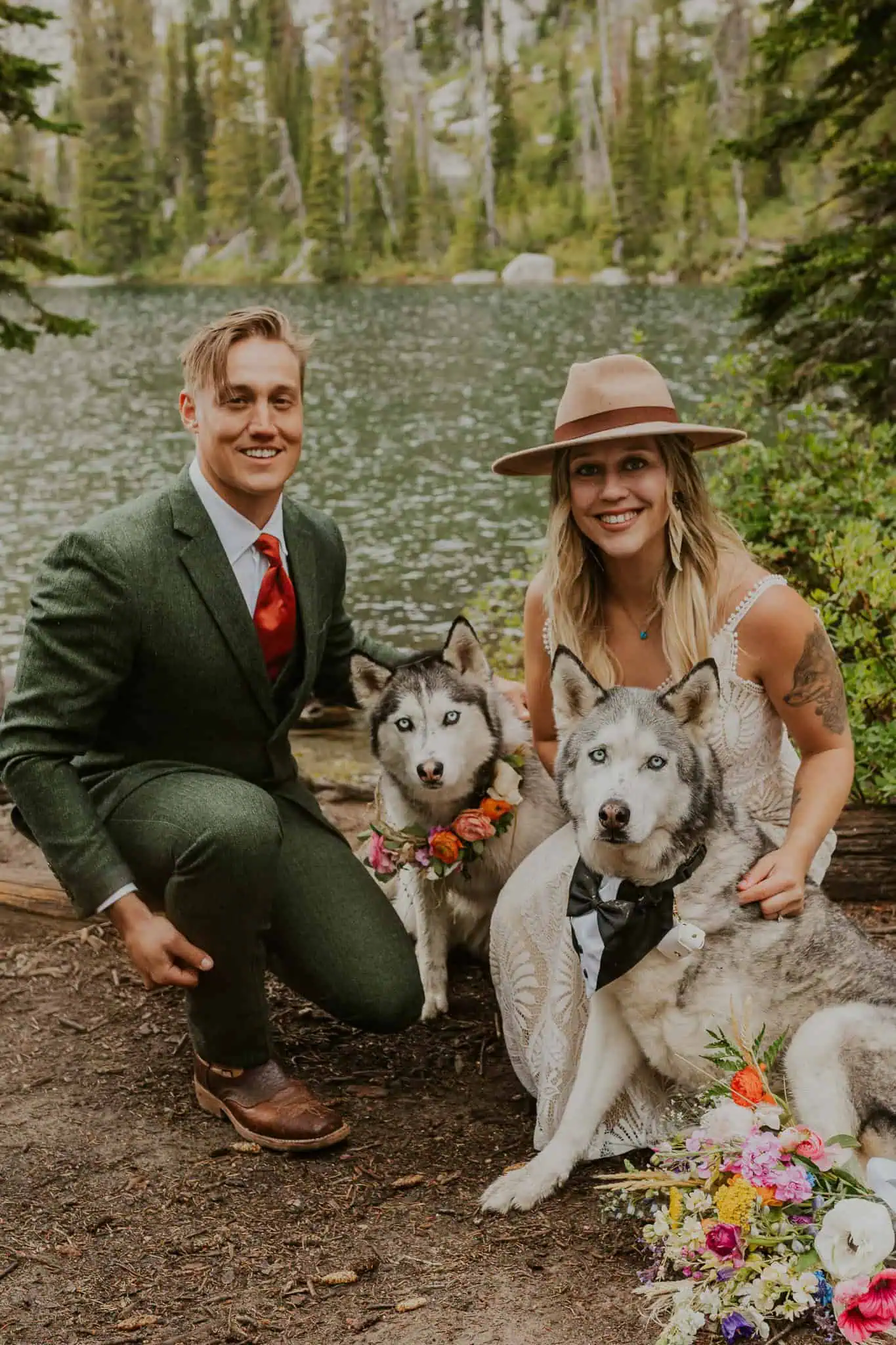 an eloping couple smiling with their huskies