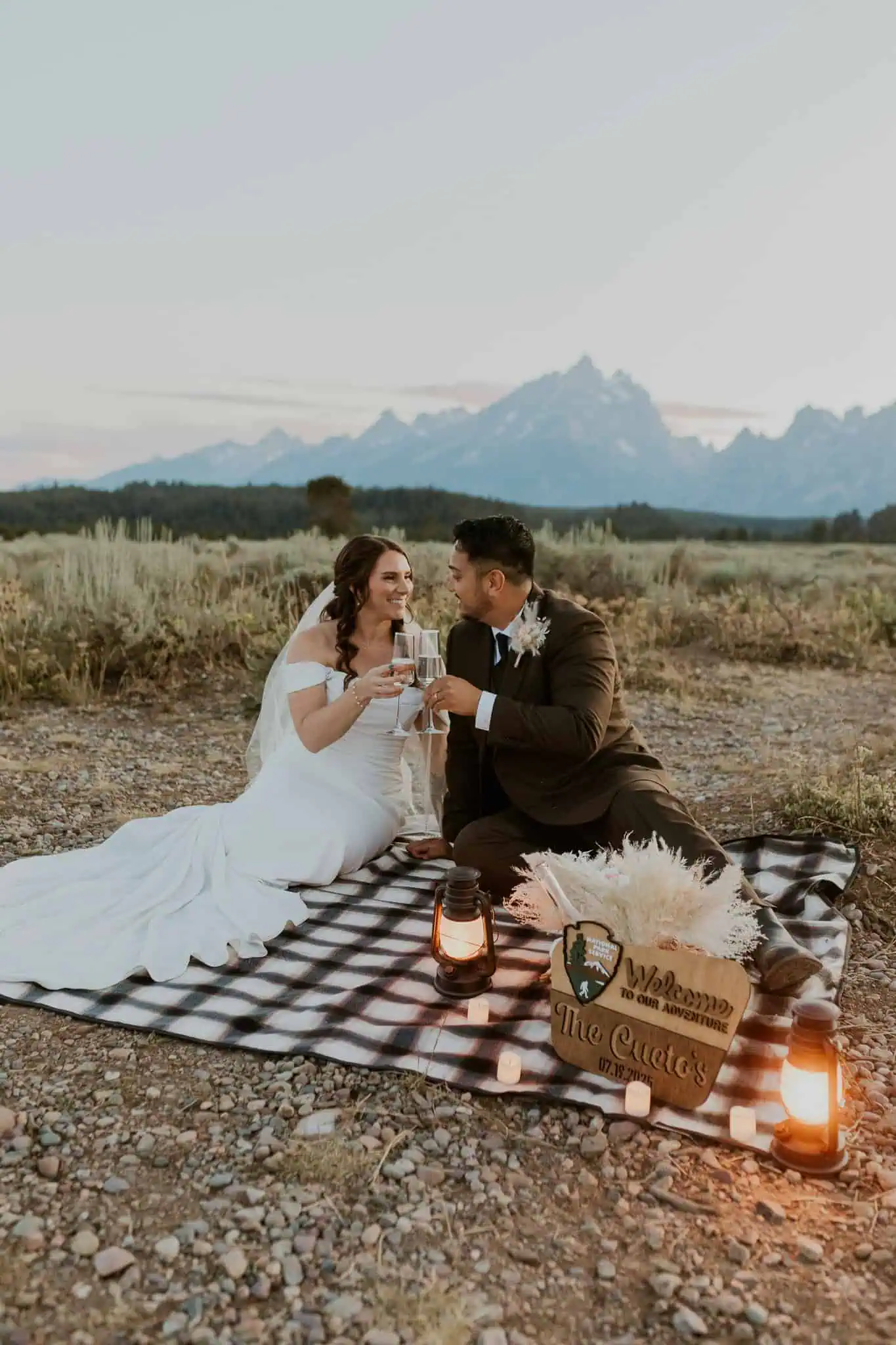 blue hour elopement picnic with champagne and lanterns