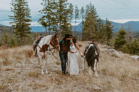 a couple walking with horses and kissing