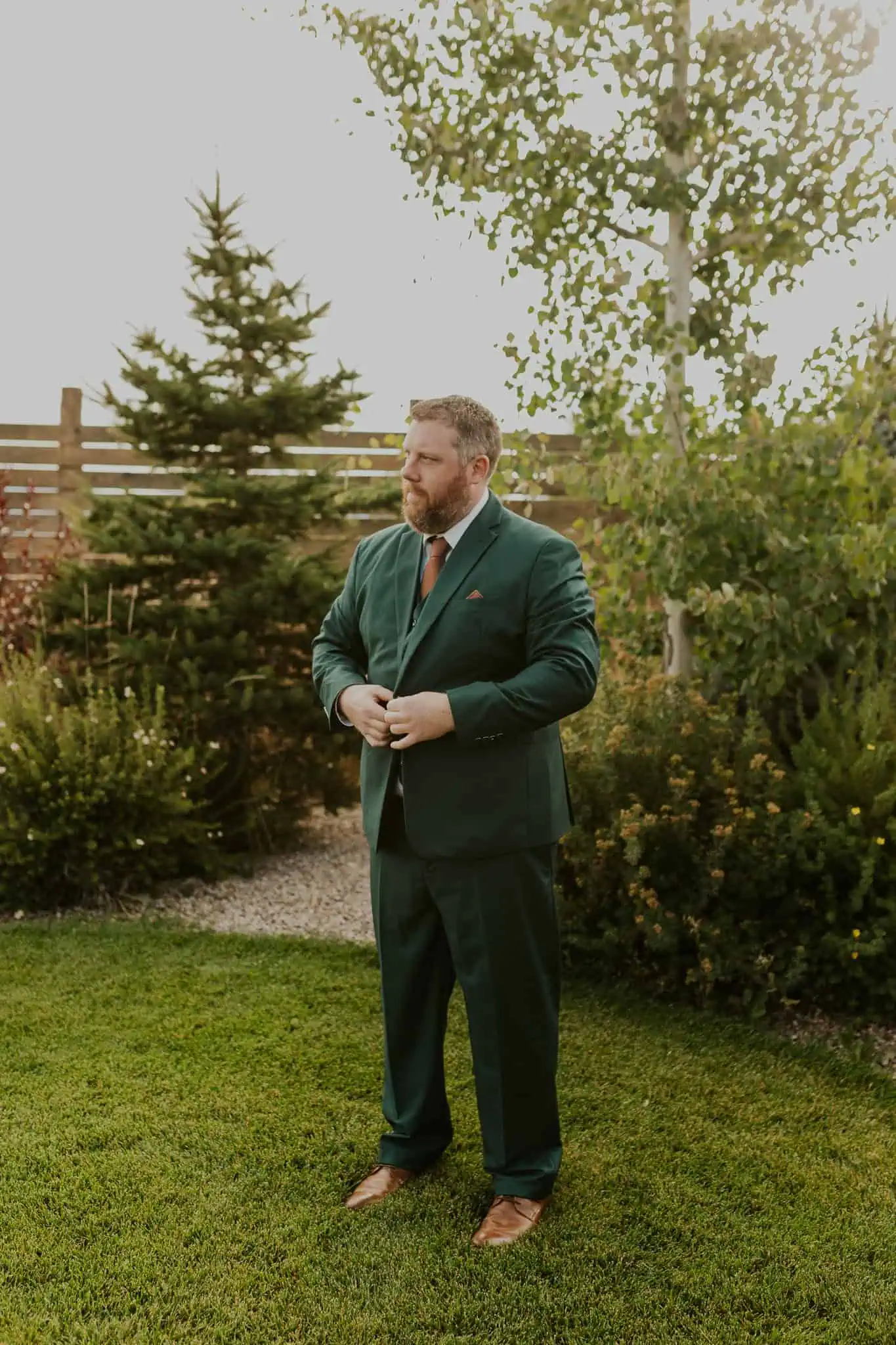 groom putting on his green suit jacket
