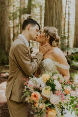 spring elopement in the forest with the bride holding a big flower bouquet