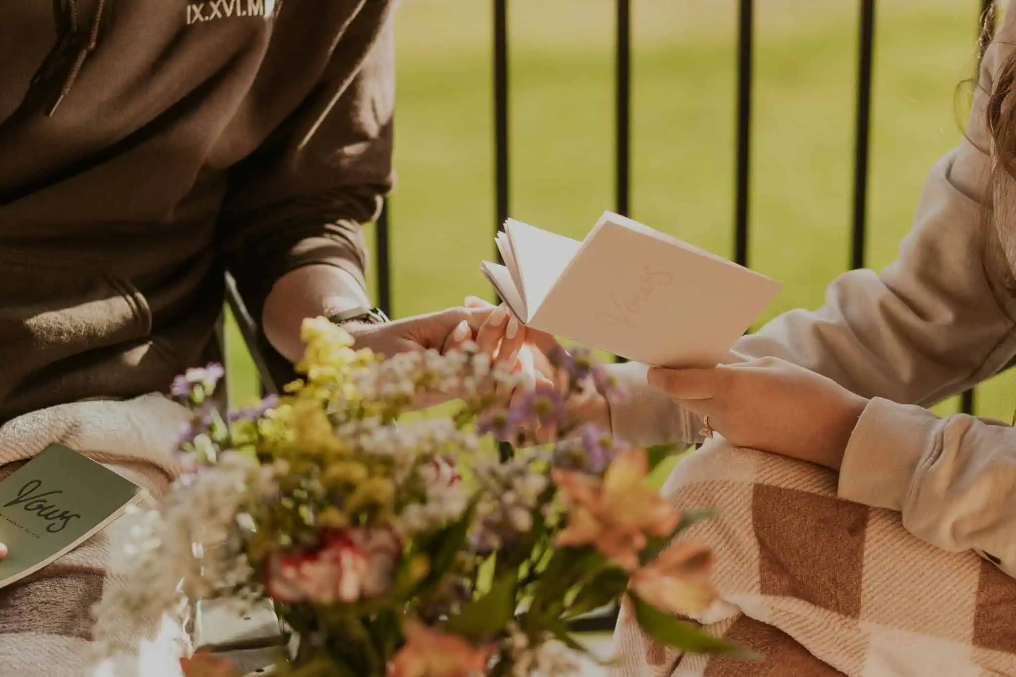 couple holding hands and reading vows