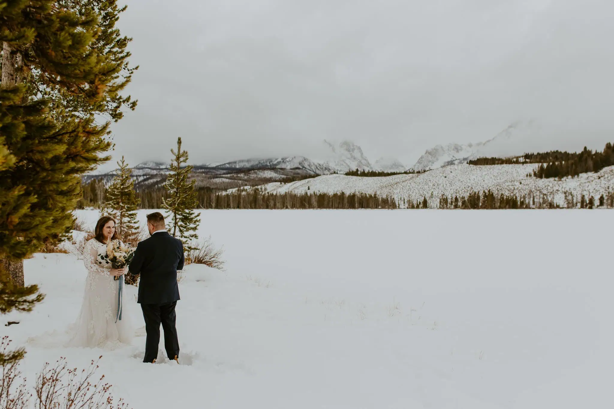 groom reading his vows in front of snowy mountains in idaho