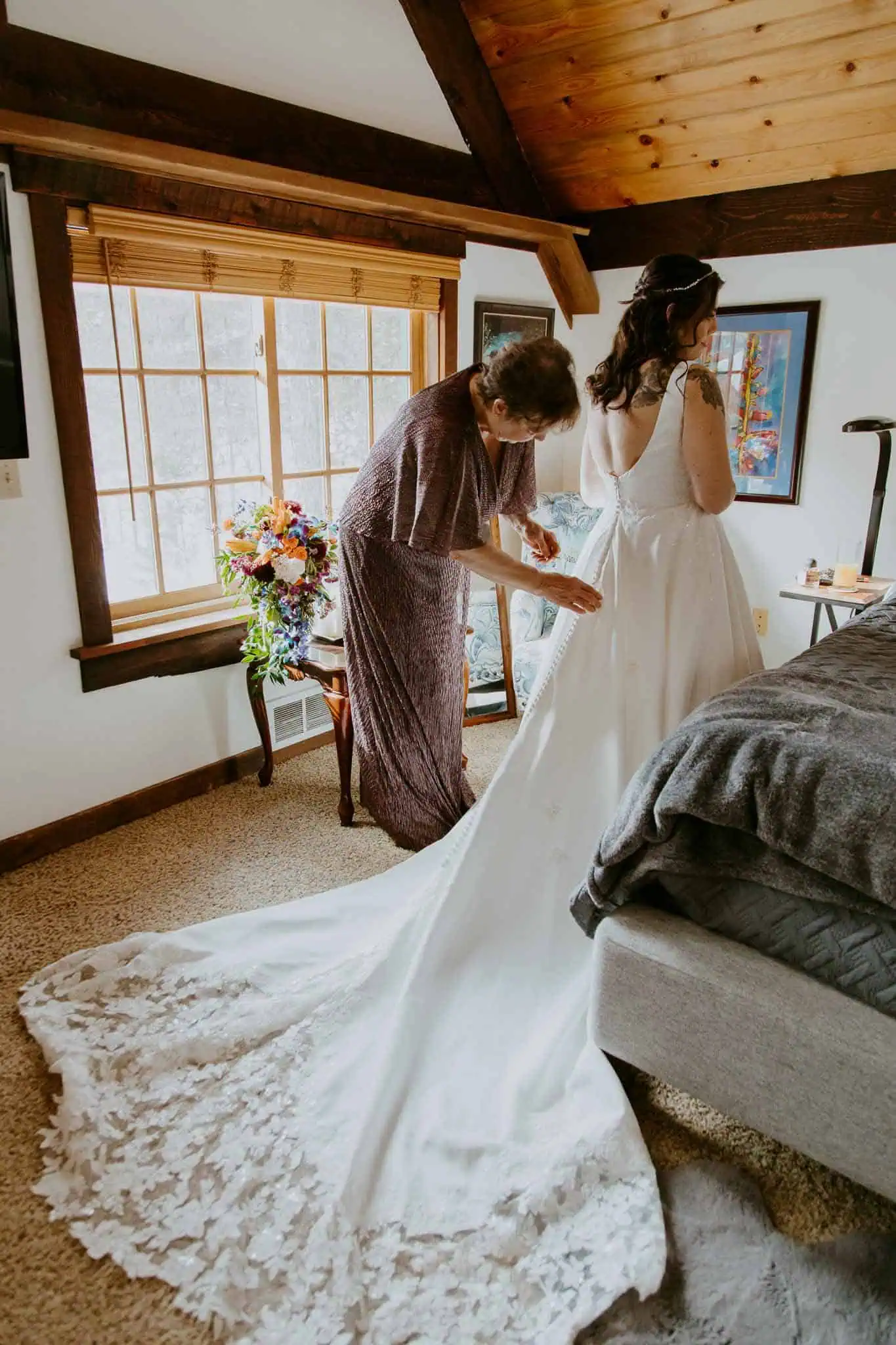 mom helping bride into dress