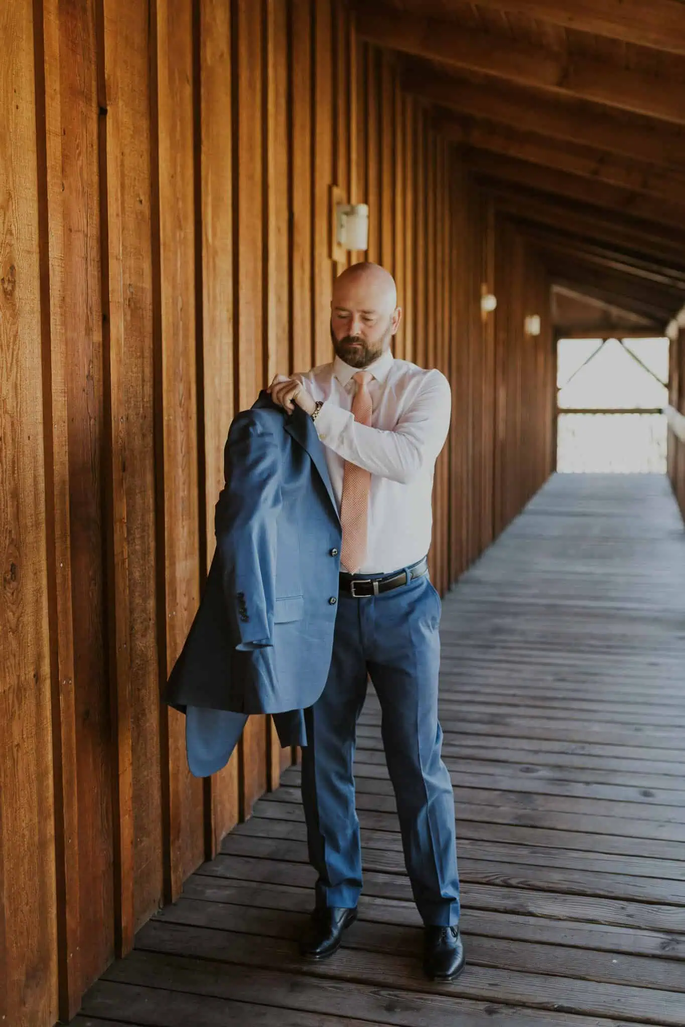 groom putting on suit coat