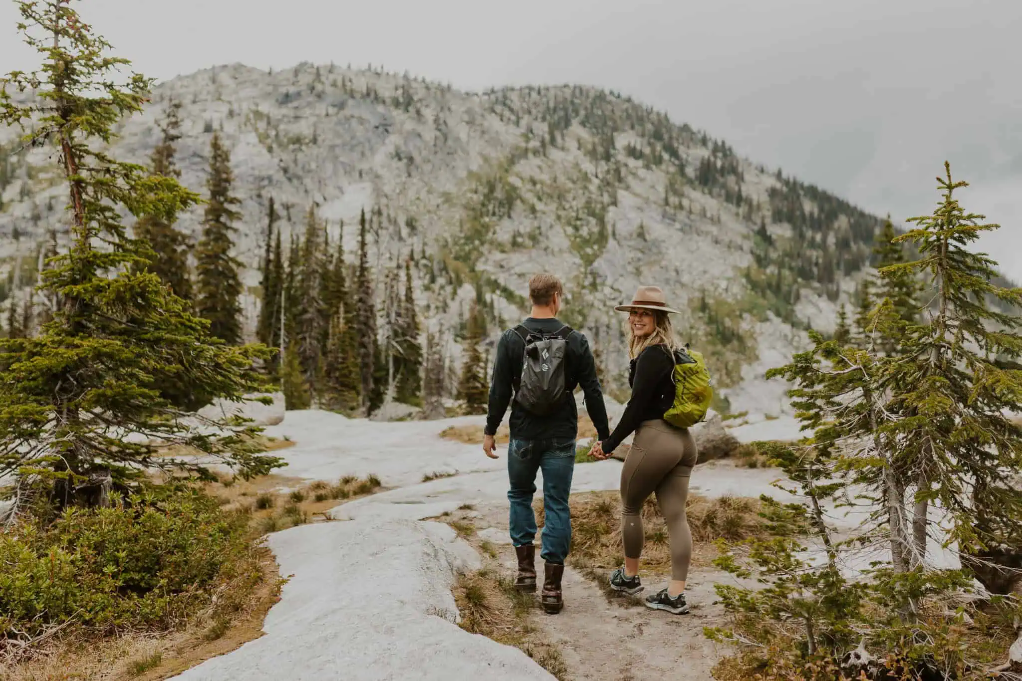 a couple holding hands while hiking