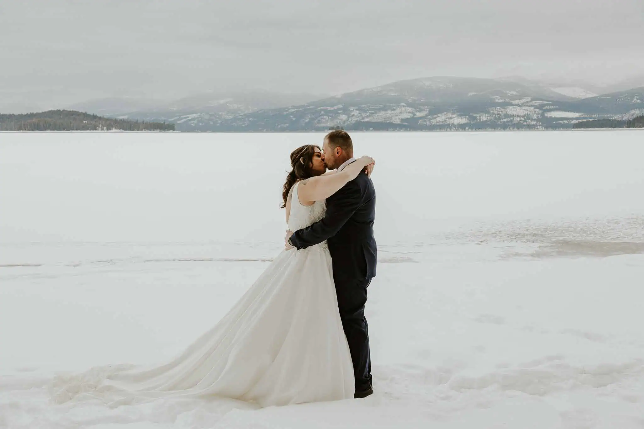 a couple kissing in the snow at priest lake