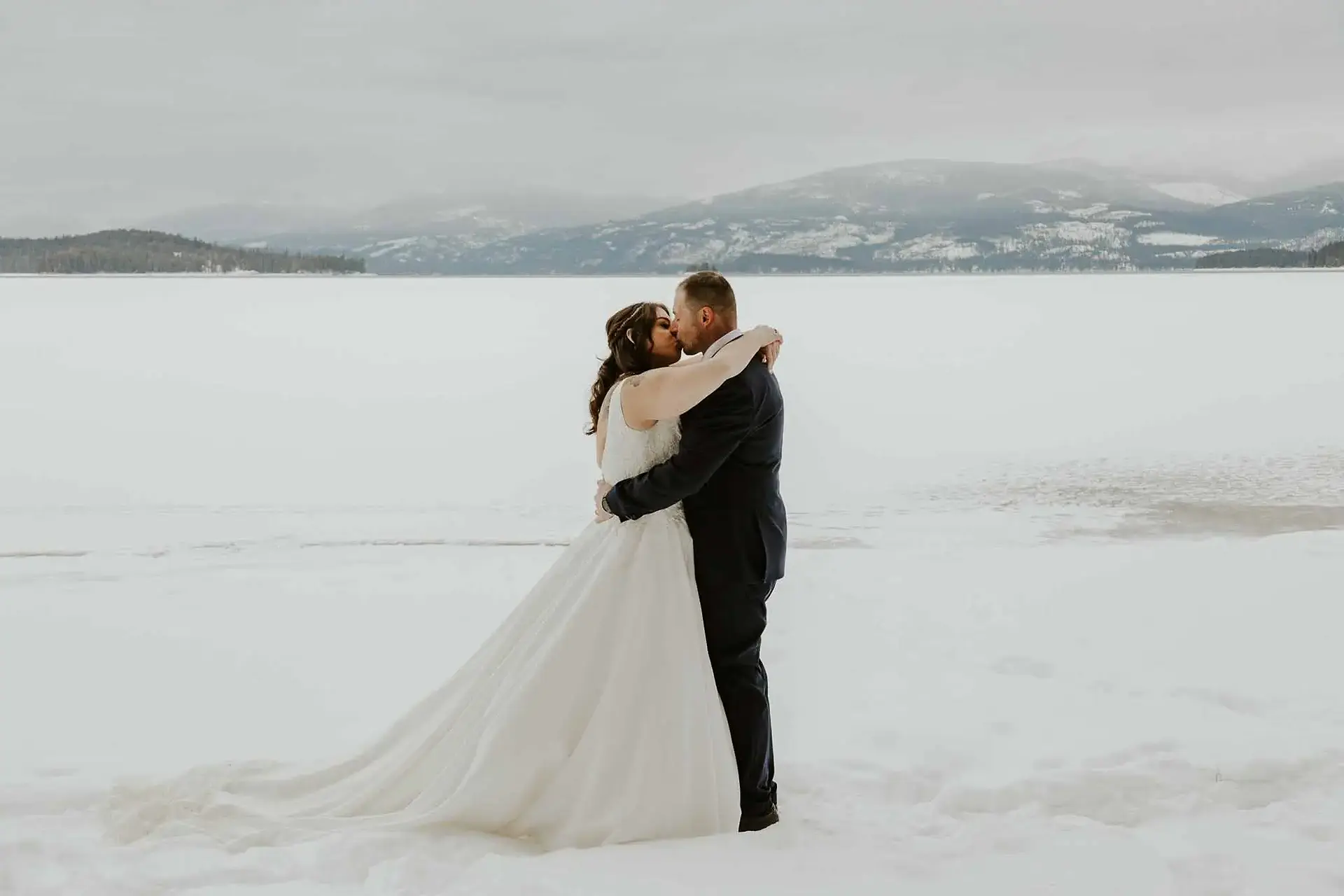 a couple kissing in the snow at priest lake