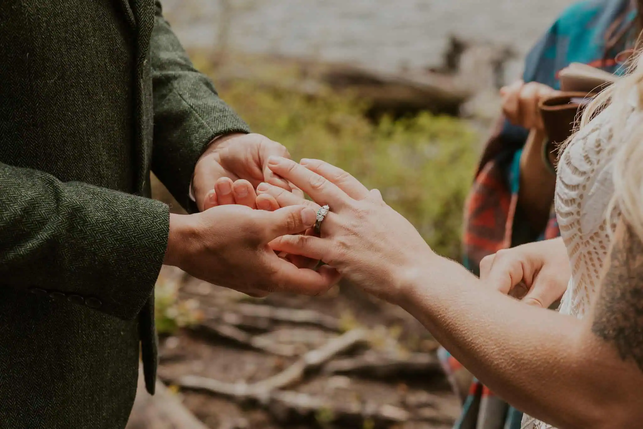 a groom putting a turquoise wedding band on his wife