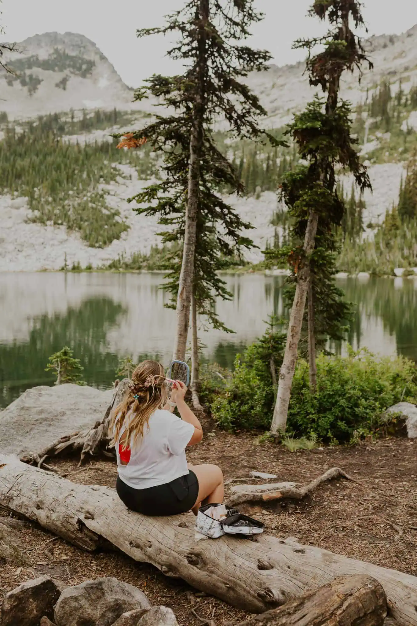 a bride putting on makeup in the mountains