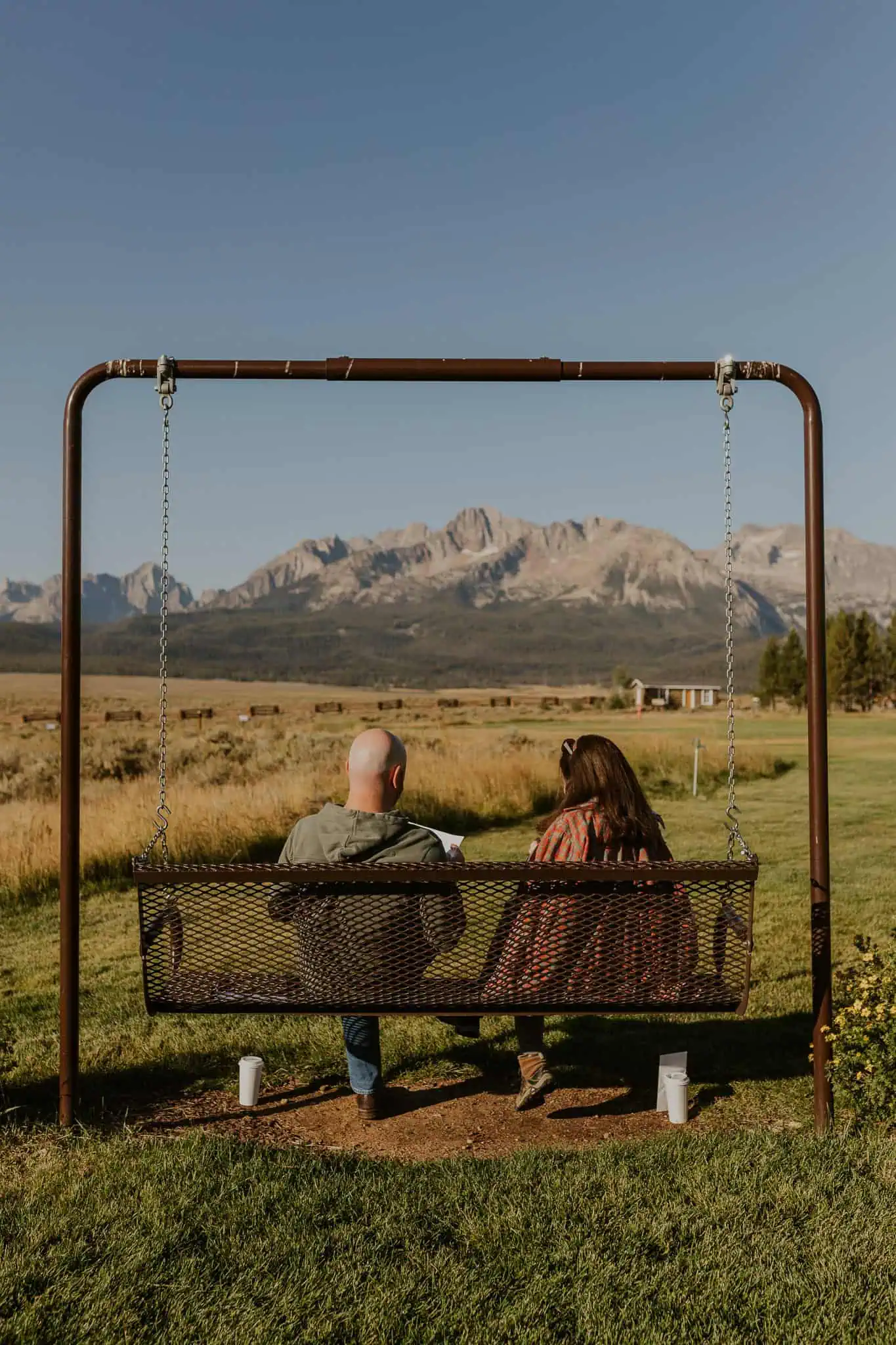 couple sitting on a park swing