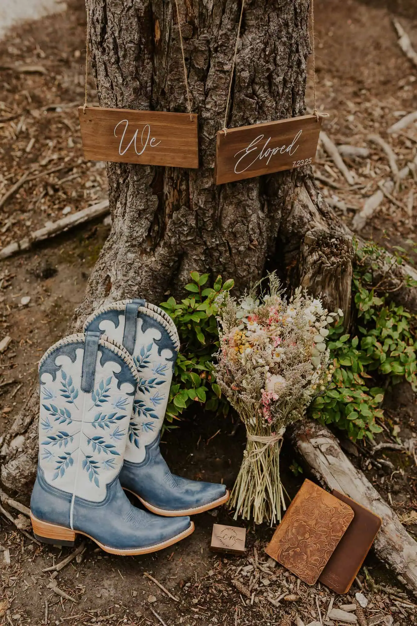 elopement details with we eloped signs and blue boots