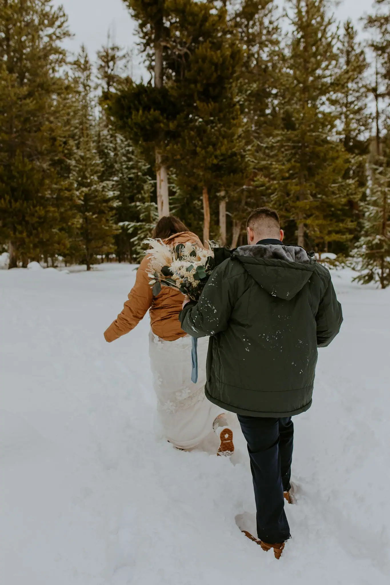 bride and groom trudging through snow