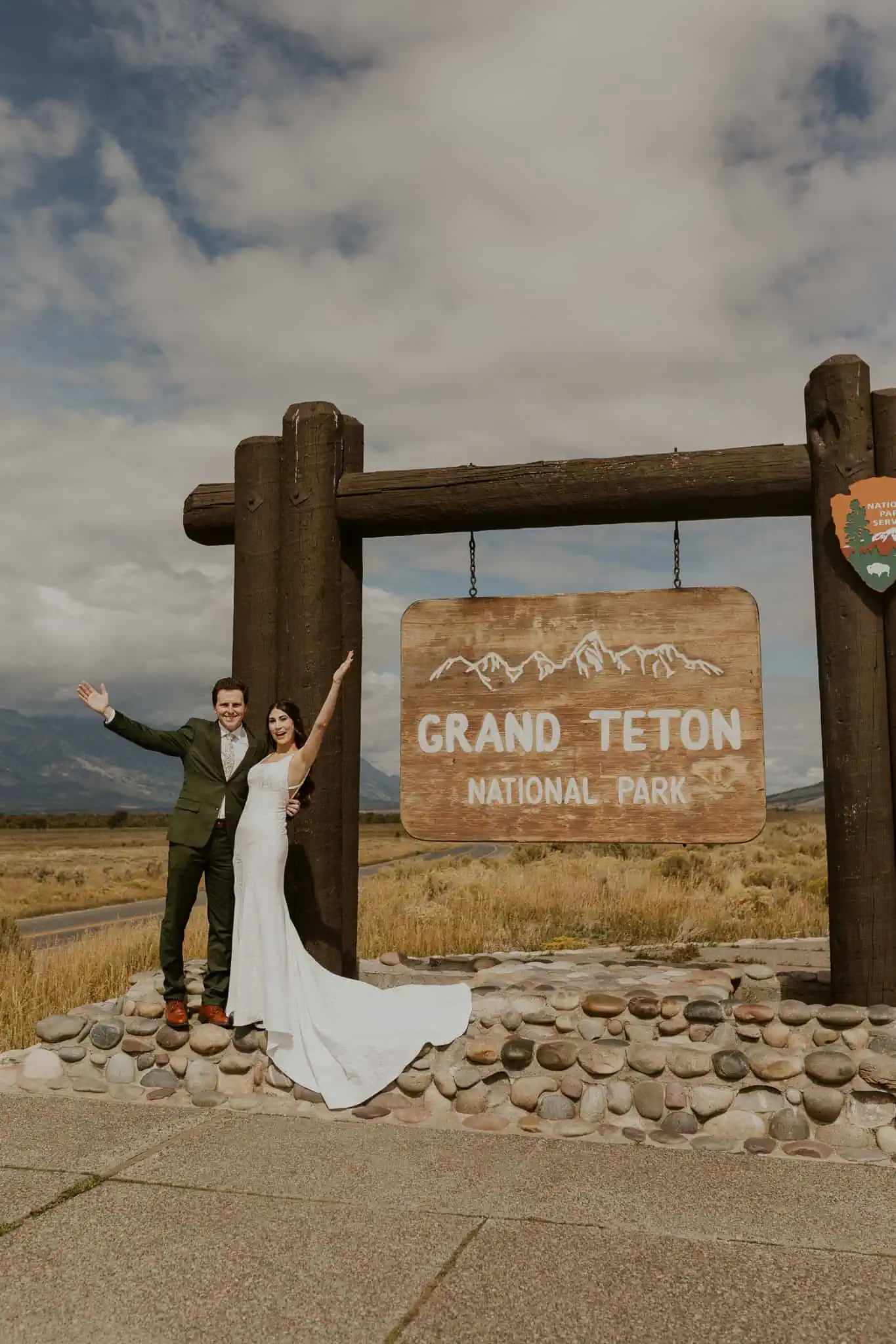 couple in wedding attire by grand teton sign