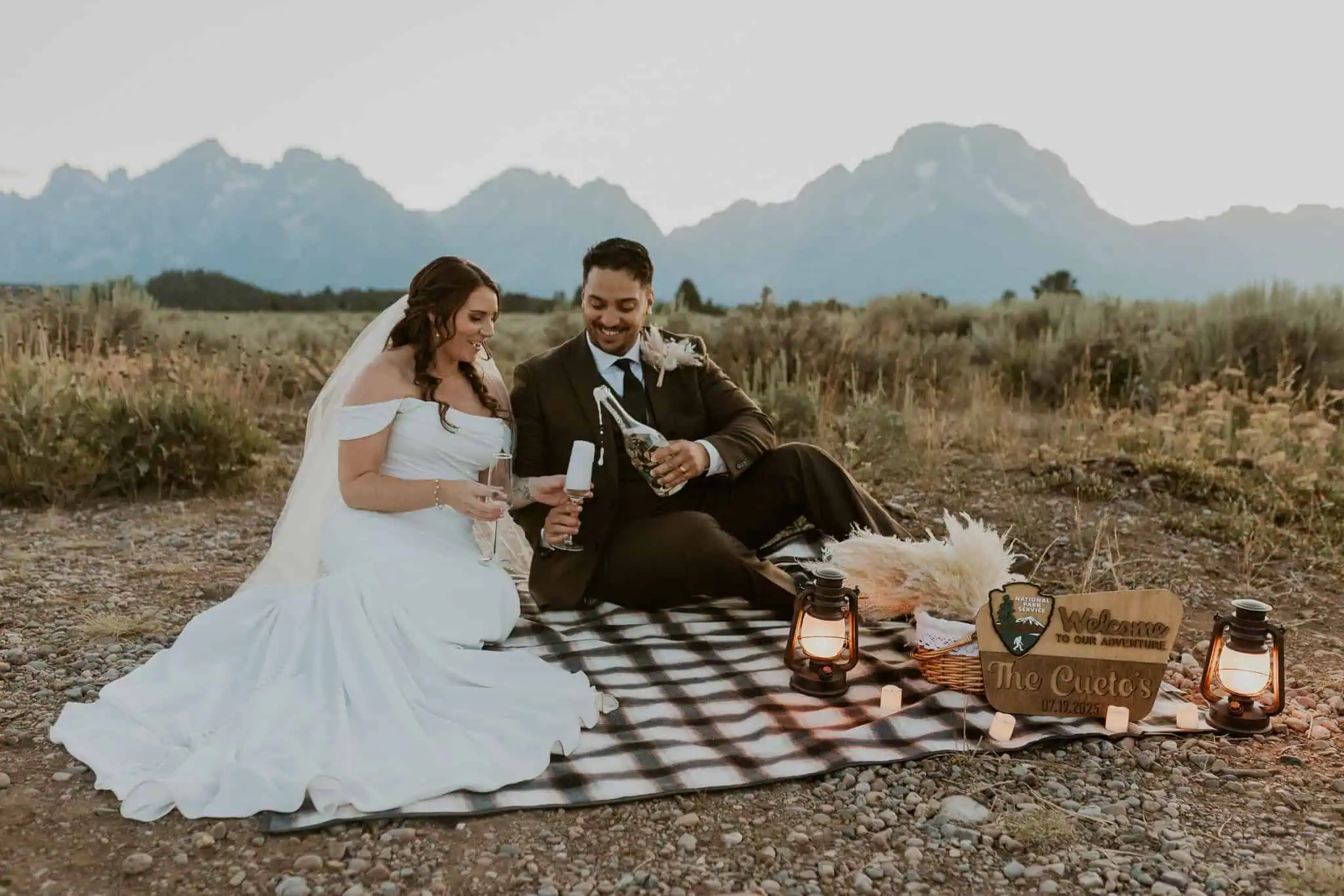 an elopement picnic at blue hour with champagne and lanterns