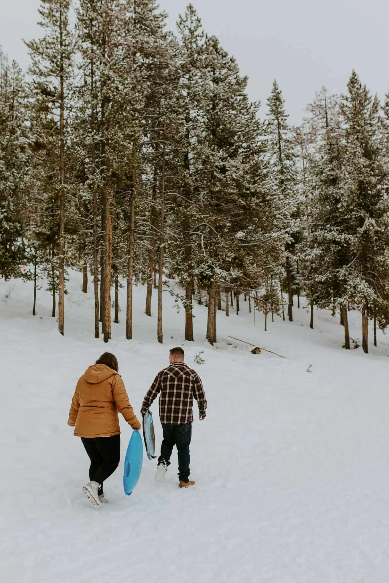 a couple going sledding in the snow at galena lodge