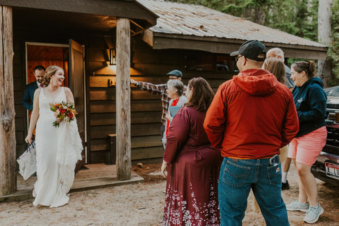 bride greeting her family at a cabin