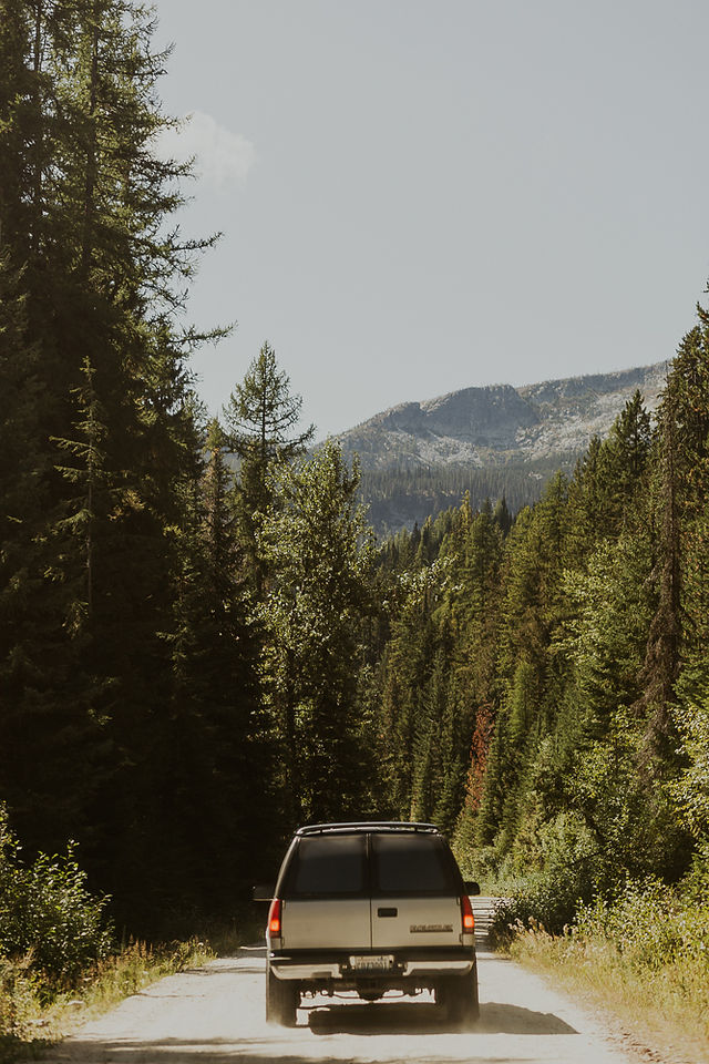 the bride and groom driving on a mountain road in their vehicle