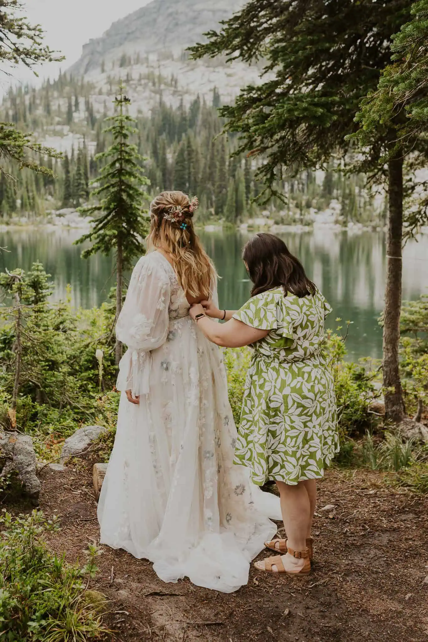 bride's mom helping bride get into her dress