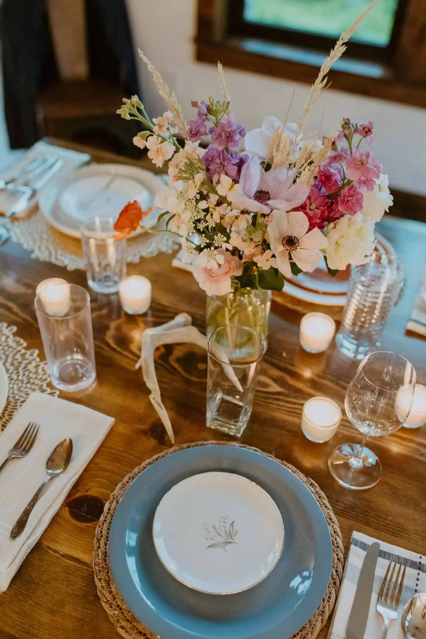 a dinner table with flowers and blue plates
