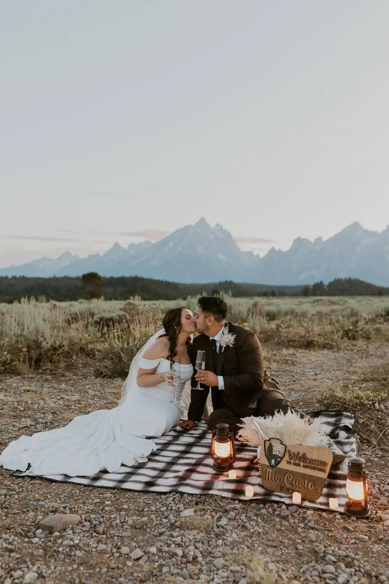 an elopement picnic at blue hour with champagne and lanterns