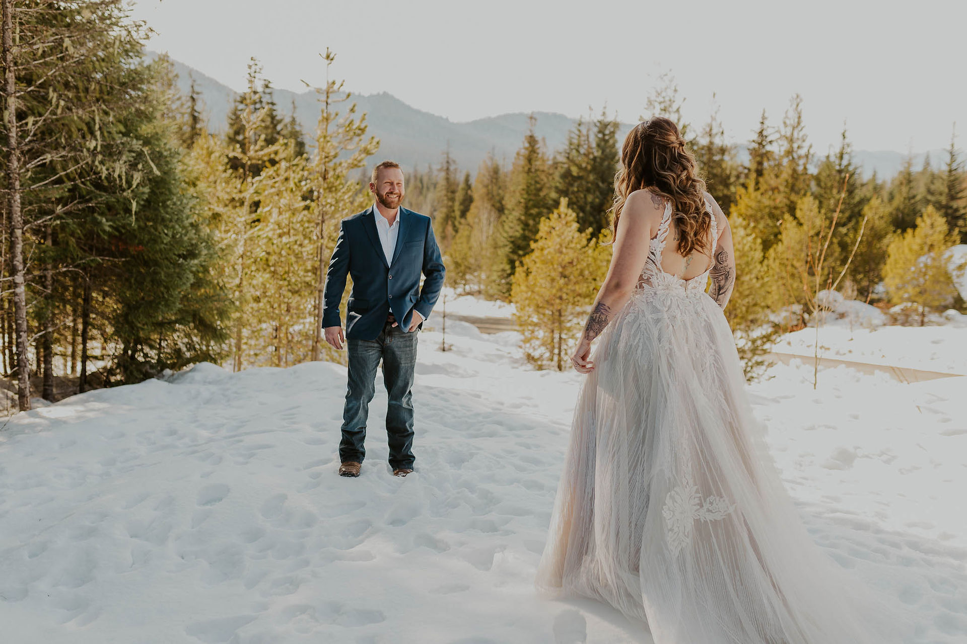bride and groom first look in the snow with mountains in the background