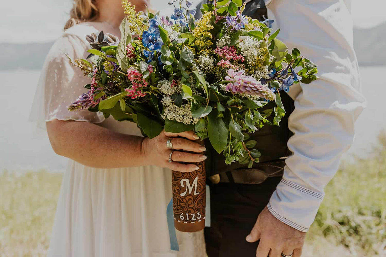 an up close photo of a wildflower bouquet with a monogrammed leather wrap
